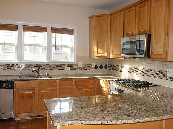 Bright beautiful kitchen with granite counter-top and stainless steel appliances