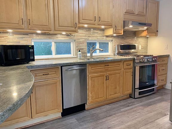 Kitchen with tons of storage, granite counters, custom backsplash and gas stove.