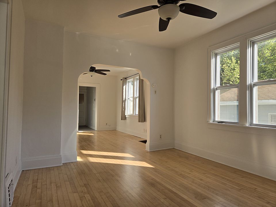 Living room looking west into the dining room and storage area leading to the side entrance
