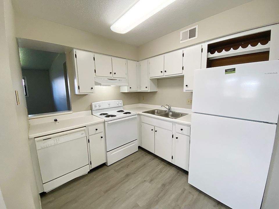 KITCHEN FROM DINING AREA; STOVE DISHWASHER, REFRIGERATOR WITH BUILT IN WINE RACK ABOVE