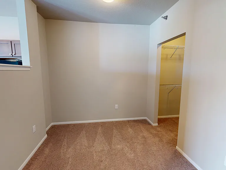 The Poppy studio apartment provides a semi-private bedroom with carpet and a walk-in closet. The Poppy studio apartment provides a semi-private bedroom with carpet and a walk-in closet.