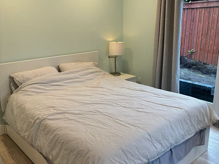 Main floor bedroom with sliding door to side yard and private yard/deck.