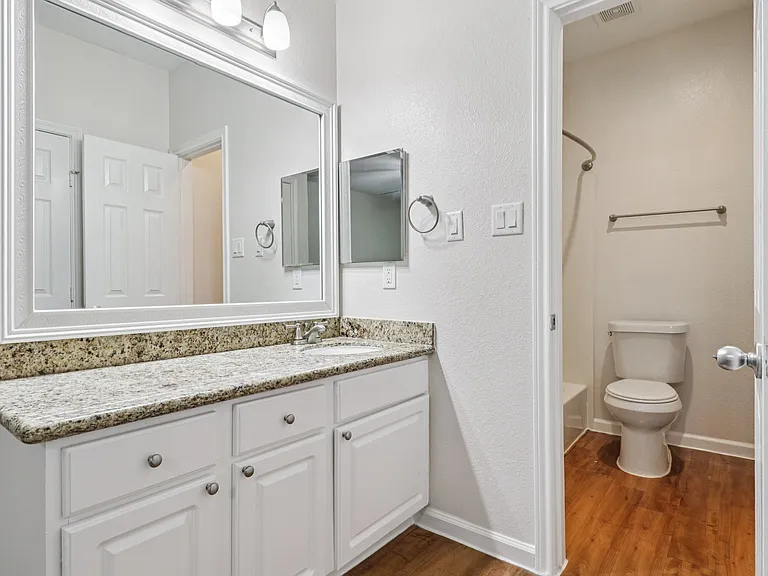 Elegant bathroom featuring sleek countertop, large mirror, and modern fixtures. Elegant bathroom featuring sleek countertop, large mirror, and modern fixtures.