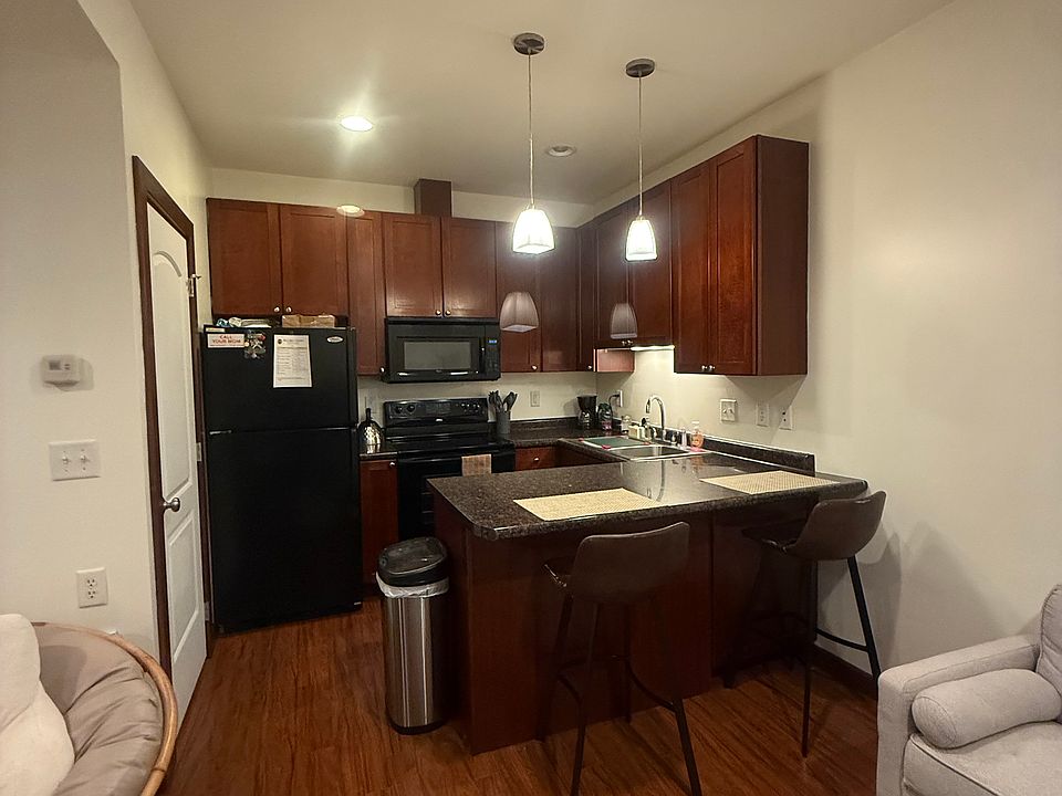 Adjacent to the living room, the bar features two comfortable chairs with backrests, perfect for meals, studying, or working. A bright, versatile space seamlessly connected to the living area, ideal for coffee, casual bites, or catching up on work.