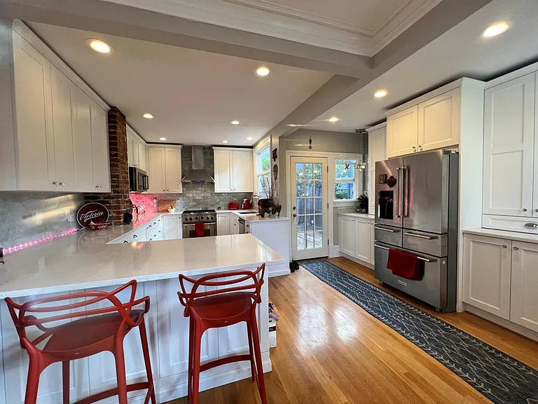 Kitchen is open concept kitchen with bar seating are and doorway to back deck and bbq.