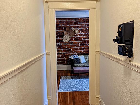 View when you enter the front door of the unit. Original (non-working) wall mounted phone. Straight into the living/bedroom. Right into the kitchen