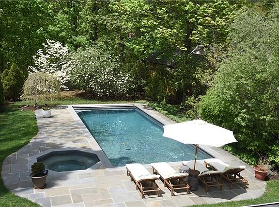 Enjoy summer in this incredible backyard with pool and hot tub.  Mature plantings give total privacy in the summertime.  Distant river view in the fall and winter seasons.