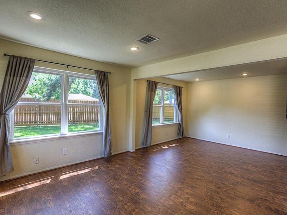 The living room features wonderful views of the side yard and has recessed lighting.