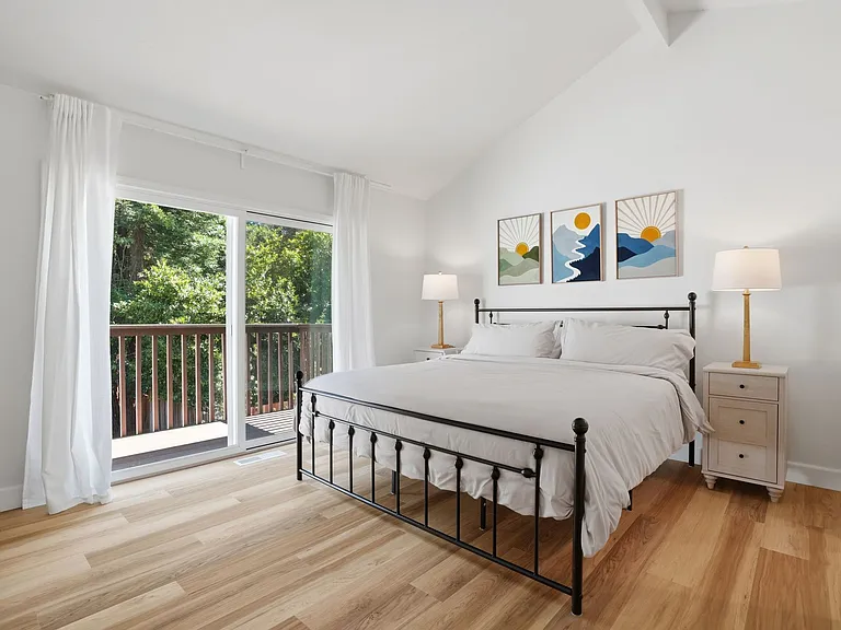 Another Primary Upstairs with king bed and dresser with balcony deck overlooking the golf course