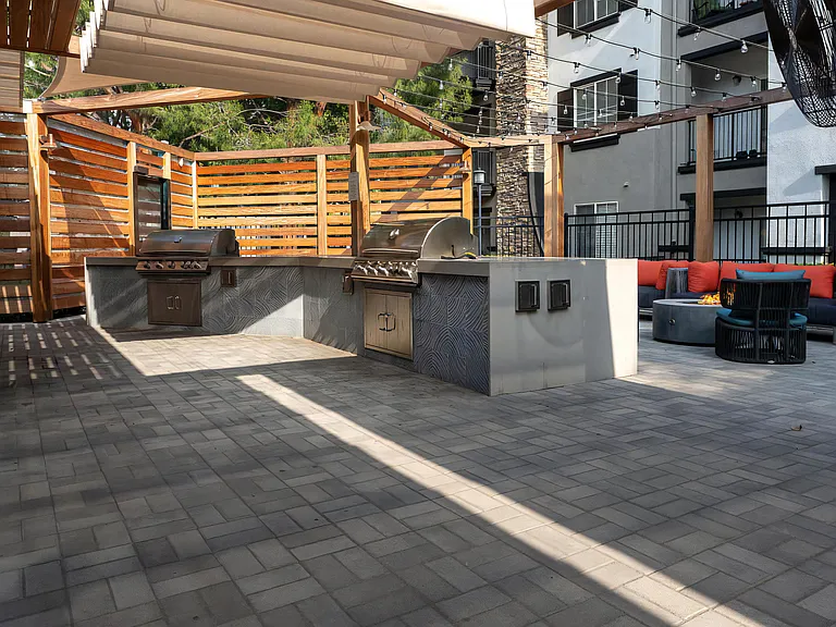 Covered Outdoor Kitchen with Dual Stainless Steel Grills and Lounge Seating