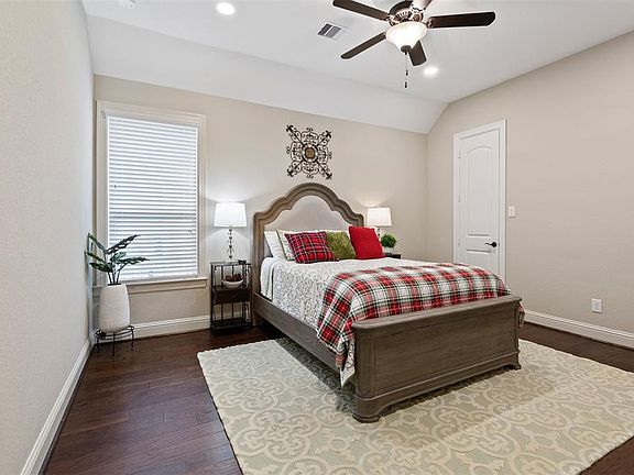 1st secondary bedroom featuring hardwood floors, walk-in closet and ample room for queen bedroom set.