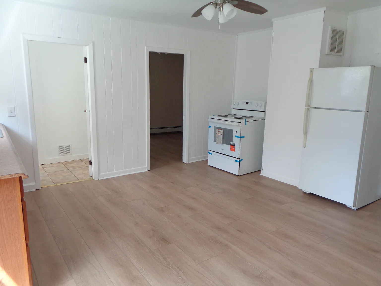 Bright Sunny Kitchen with New Flooring, New paint, New windows, New ceiling, New stove, New Refrigerator, New ceiling fan/light fixture, New window shades.