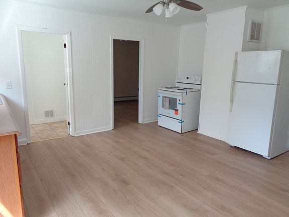Bright Sunny Kitchen with New Flooring, New paint, New windows, New ceiling, New stove, New Refrigerator, New ceiling fan/light fixture, New window shades.