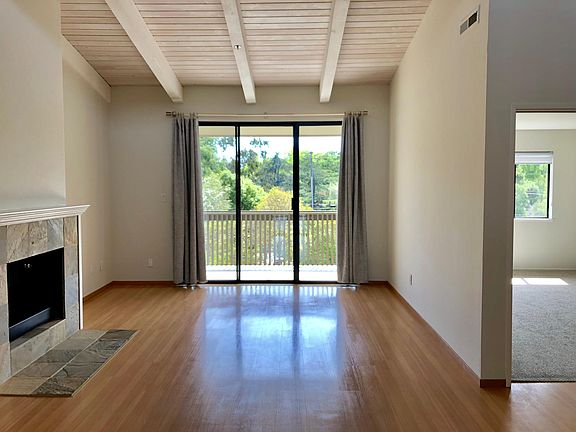 Living room with Pergo flooring, gas fireplace, high ceilings and West facing covered balcony