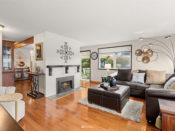 Electric fireplace insert accented by white brick and wood mantle. 