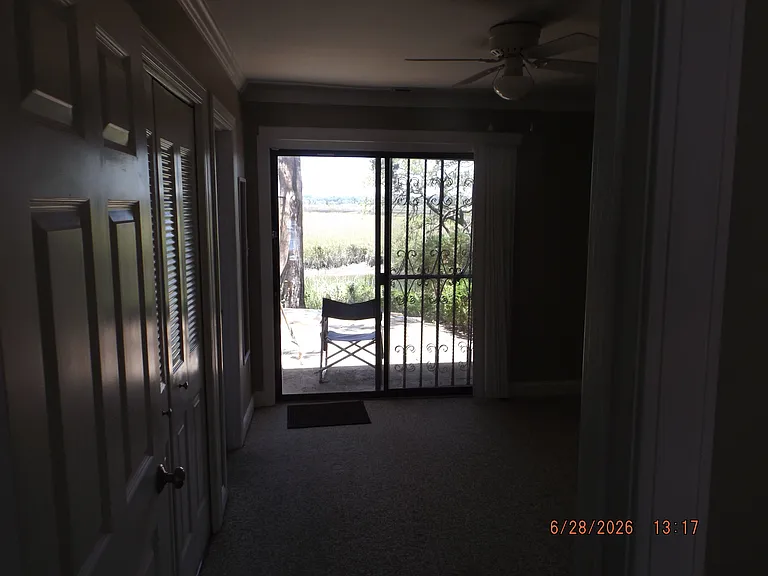 bedroom with sliding door, vertical blinds, lockable iron gates, and back patio