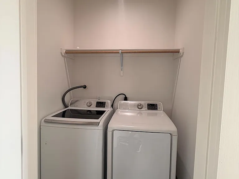 Dedicated laundry closet with full-size washer and dryer, overhead shelf, and easy-access in-home convenience.