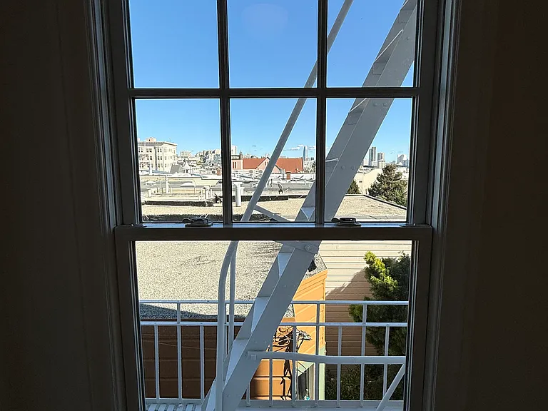 Window in breakfast nook area. Freshly painted fire escape (entire exterior of building has fresh clean paint).