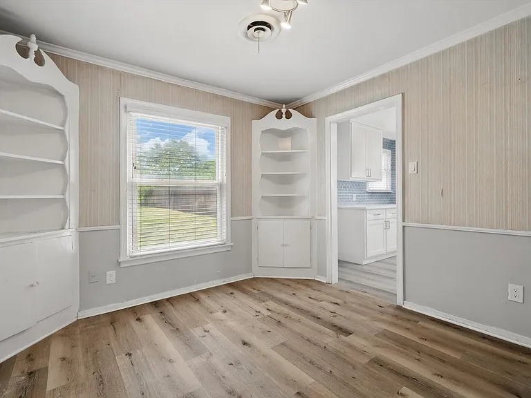 This charming dining room has beautiful architectural detail with the corner built-in cabinets and view of the back yard