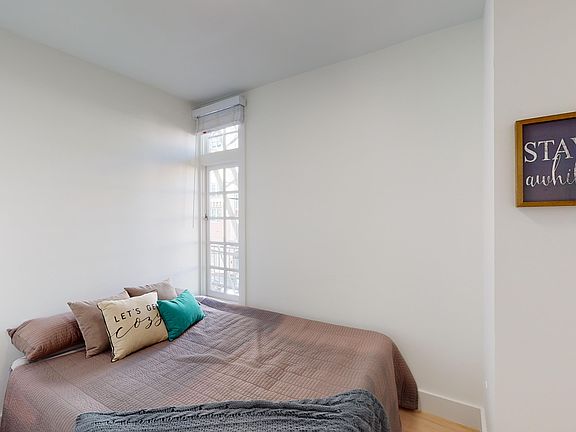 Serene and cozy bedroom with a window allowing natural light to filter in