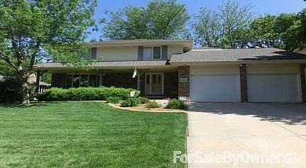 Front is landscaped with perennials and has two trees.
