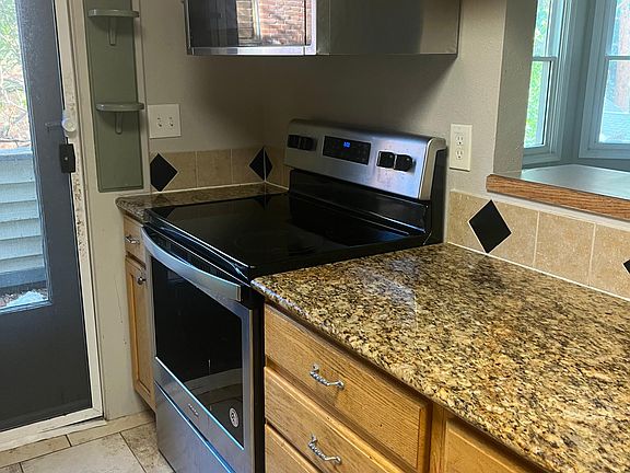 Kitchen with stainless steel range, microwave, dishwasher, and refrigerator. Granite countertops.