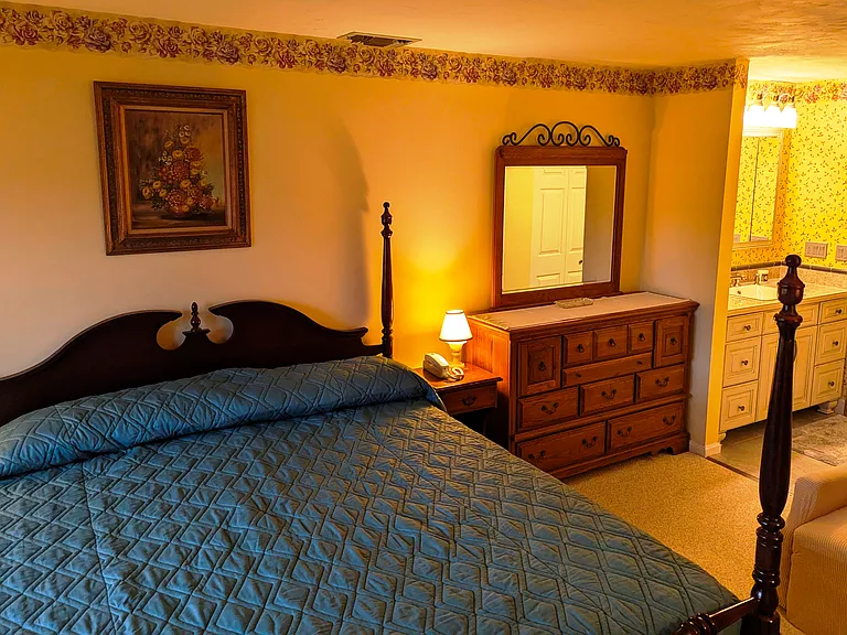 master bedroom bureau, reclining chair, ensuite vanity and bathroom areas