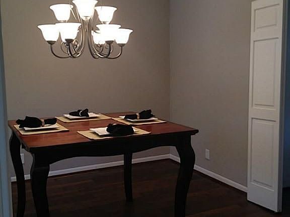 Dining room with updated light fixture, wood floors, boxed window.