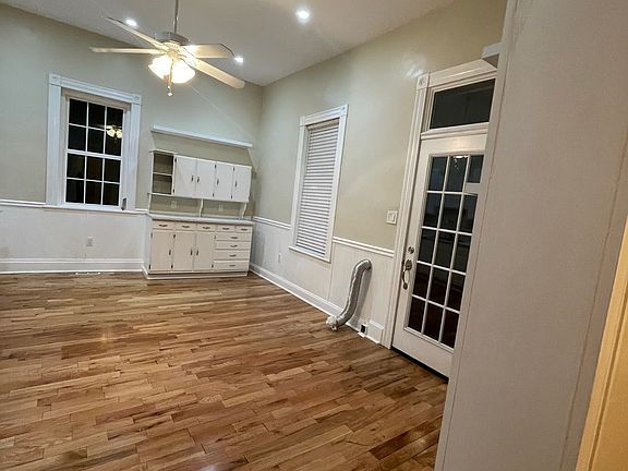 Right view of the kitchen and back entry door with transom window. Washer dryer hookups are in this room. Door on the antique cabinet will be re attached. Has custom shelves on the walls too.