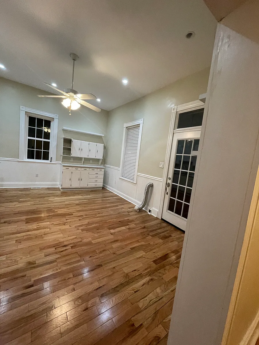 Right view of the kitchen and back entry door with transom window. Washer dryer hookups are in this room. Door on the antique cabinet will be re attached. Has custom shelves on the walls too. - 607 17th St