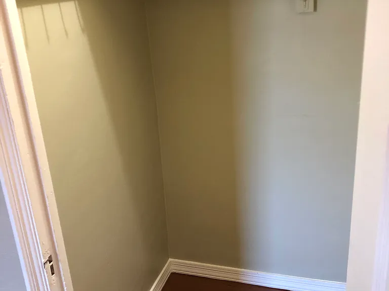 King size bedroom: Closet with shelf and hooks in closet.
