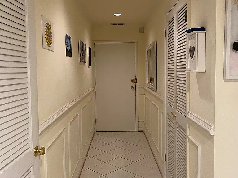 Entrance hallway with large coat and storage closet (left) and washer/dryer closet (right)