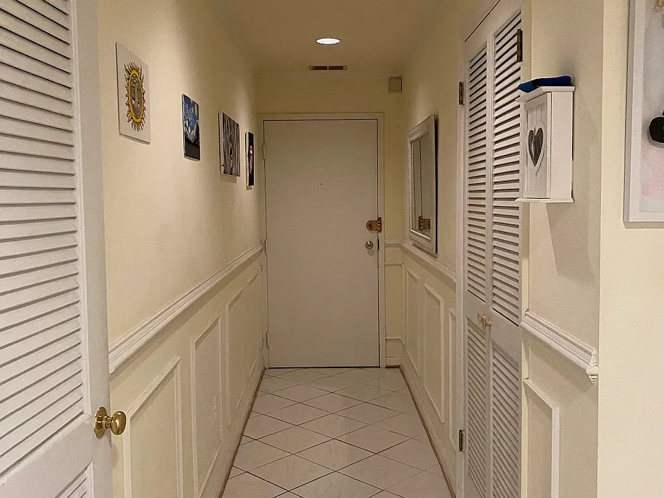 Entrance hallway with large coat and storage closet (left) and washer/dryer closet (right)