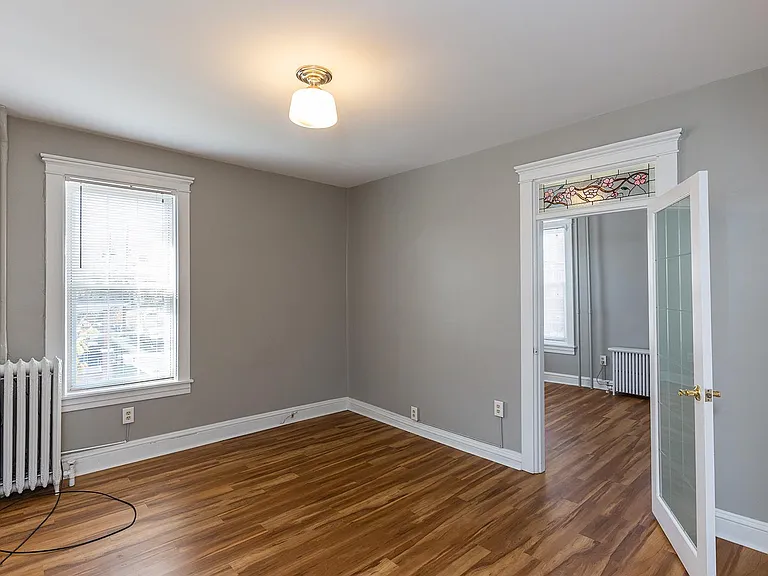 Living room, looking into bedroom 1, with stained glass door detail.