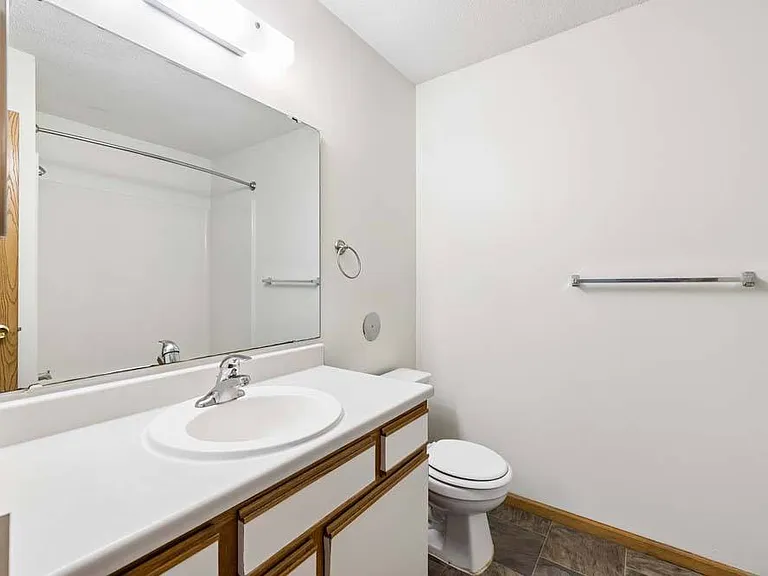 A large mirror and spacious vanity create a bright, functional bathroom designed for everyday comfort.