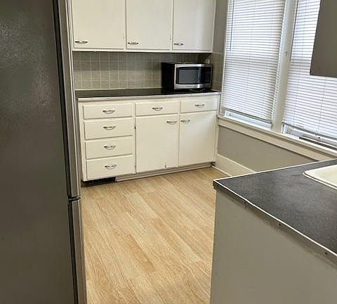 This is the view standing at the exterior entrance into the kitchen. Counter and storage on both side of kitchen. Windows are north facing and bring in lots of light.
