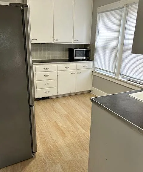 This is the view standing at the exterior entrance into the kitchen. Counter and storage on both side of kitchen. Windows are north facing and bring in lots of light.