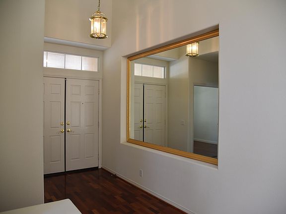 Double door entry to this foyer with high ceilings and mirrored wall