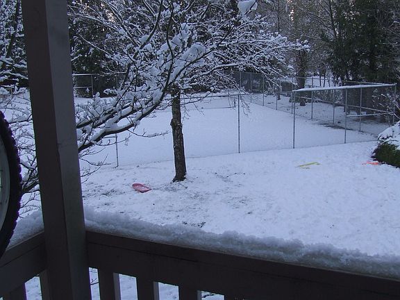 View of snow-covered tennis court from balcony