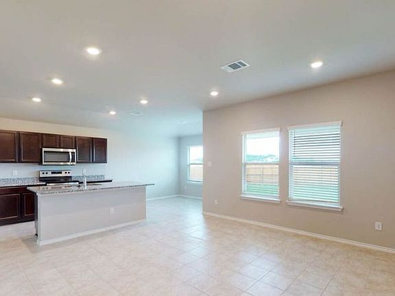 Bright, open living space with tile floors, backyard views, and a kitchen built for entertaining.