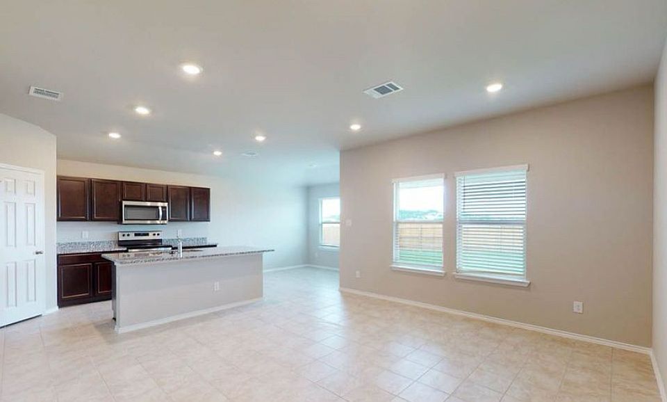 Bright, open living space with tile floors, backyard views, and a kitchen built for entertaining.