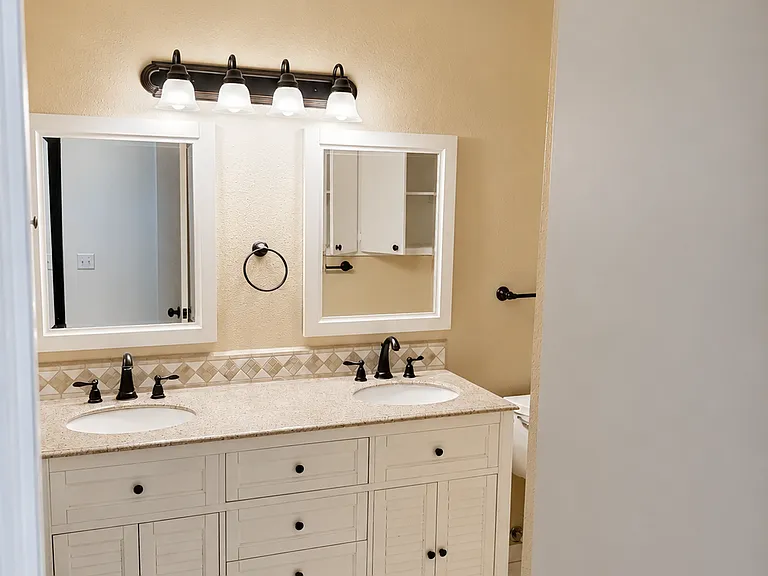 Bathroom vanity with updated countertop, storage cabinets, and mirror.