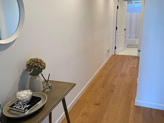 Entrance. Bedroom to the right across from table and another bedroom down the hall next to the bathroom past the stair case.