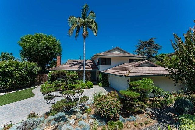 Interlocking paver driveway, artificial turf and professionally designed landscape make for an impressive entrance to the home.