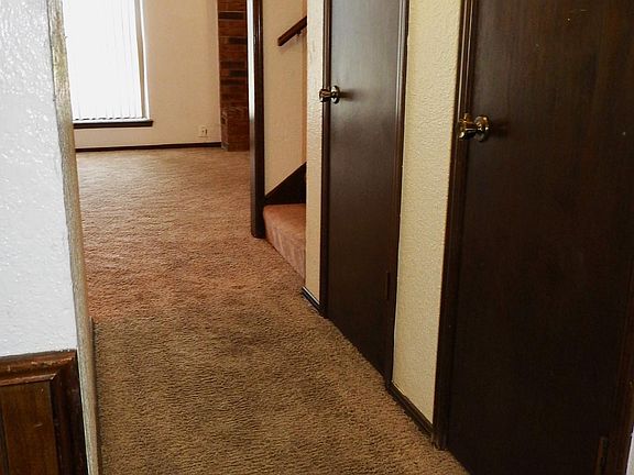 Hallway between kitchen and living areas. One of the doors is a closet underneath the staircase that has tons of storage space.