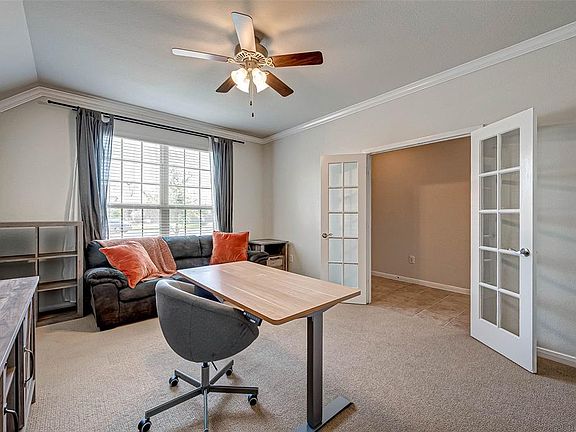 Just past the front door and through the French doors is this great versatile room that can be used as a game room, home office or gym. It features high ceilings, crown molding, plush carpet, a ceiling fan and a large window which allows for natural 