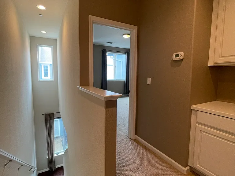 3rd Floor Hallway. This view is 2nd bedroom looking into 1st bedroom and the stairs heading to the 2nd floor.