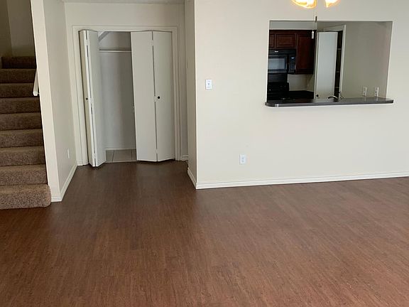 Living area looking at counter top to kitchen. Laundry to left