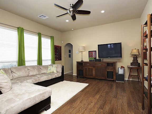 Spacious family room with upgraded ceiling fan and laminate flooring. TV and wall mount to stay. Hou