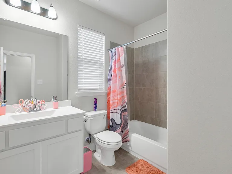 Bathroom featuring a white vanity with integrated sink, chrome faucet, and overhead three-bulb vanity light